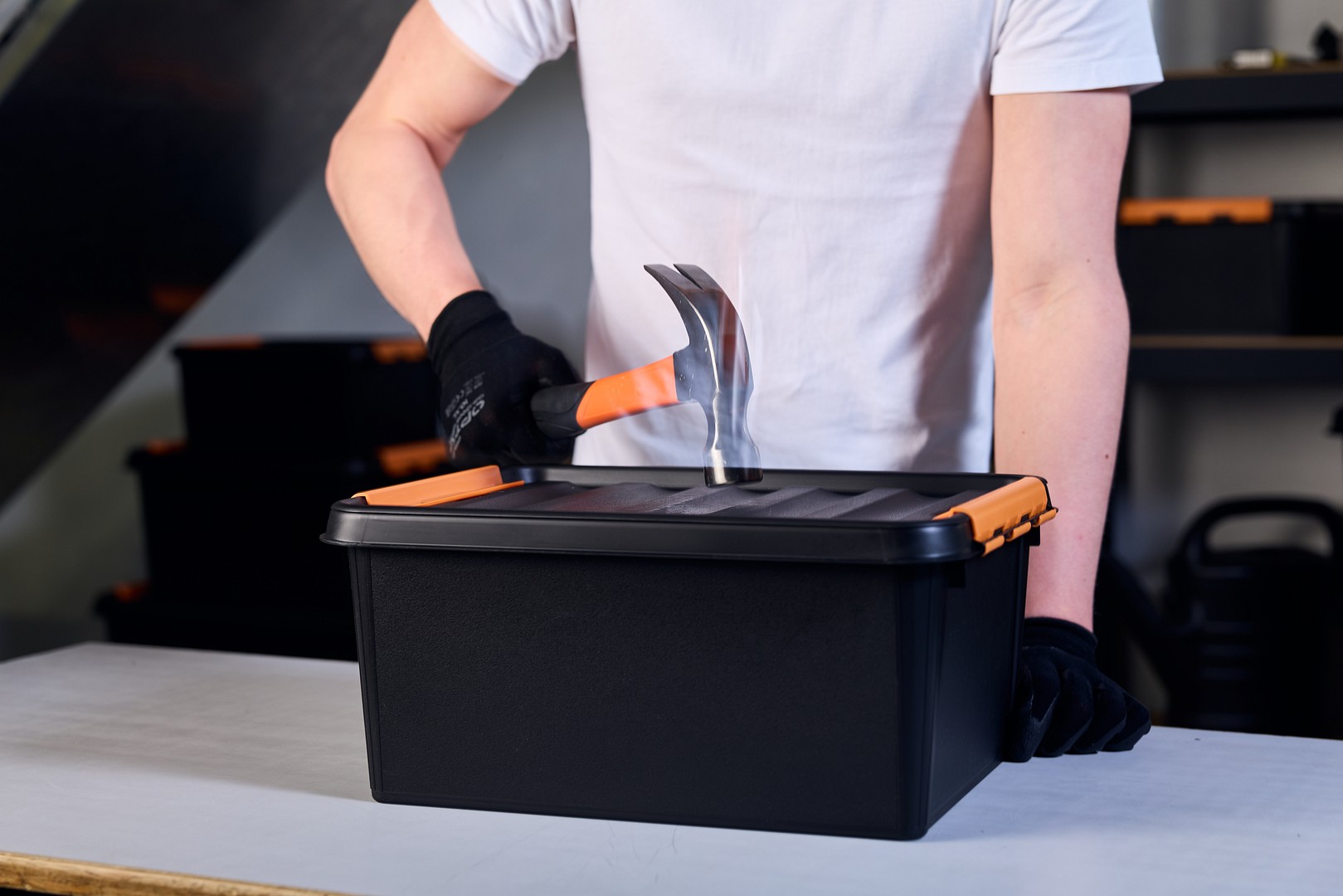 A hand with a hammer hitting a SmartStore Pro storage box