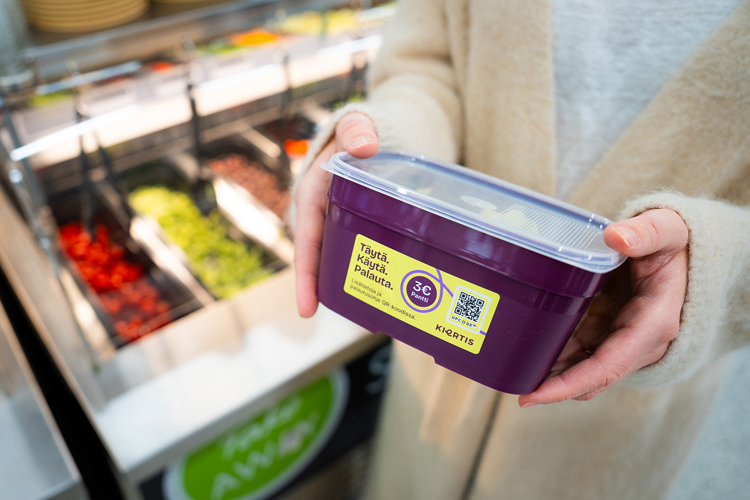 A woman holding a reusable food container